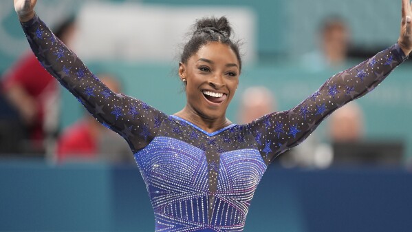 Simone Biles, of the United States, celebrates after performing on the balance beam during the women's artistic gymnastics all-around finals in Bercy Arena at the 2024 Summer Olympics, Thursday, Aug. 1, 2024, in Paris, France. (AP Photo/Francisco Seco)