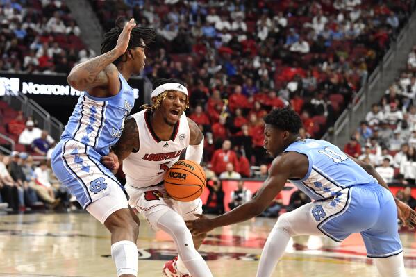 Louisville guard El Ellis (3) attempts to get past the defense of North Carolina guard Caleb Love (2) and guard D’Marco Dunn (11) during the second half of an NCAA college basketball game in Louisville, Ky., Saturday, Jan. 14, 2023. (AP Photo/Timothy D. Easley)