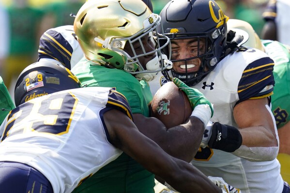 FILE - Notre Dame running back Audric Estime, center, is tackled by California cornerback Jeremiah Earby (29) and linebacker Jackson Sirmon, right, during the first half of an NCAA college football game in South Bend, Ind., Sept. 17, 2022. Sirmon is among the top players in the nation this season who are a bit under the radar because they play for schools that are not expected to win many games. (AP Photo/Michael Conroy, File)