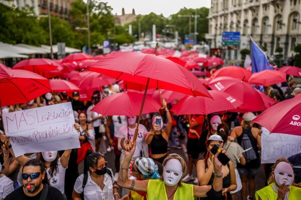 People gather during a demonstration against a bill that would penalize prostitution customers and enablers such as club owners or pimps, facing sentences up to 4 years of imprisionment in front of the Spanish Parliament in Madrid, Spain, Monday, Sept. 12, 2022. Spain is considered to be one of the less punitive legal frames for prostitution in Europe, that would turn into a so called nordic model under the new bill, punishing both clients and enablers. The banner reads in Spanish: "More legislation less prohibition". (AP Photo/Manu Fernandez)