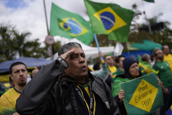 FILE - A supporter of Brazilian President Jair Bolsonaro salutes while singing the nation's anthem outside a military base during a protest against his reelection defeat in Sao Paulo, Brazil, Nov. 3, 2022. Brazil’s Supreme Court unanimously voted Monday, April 8, 2024, that the armed forces have no constitutional power to intervene in disputes between government branches, marking a largely symbolic decision aimed at bolstering democracy after years of increasing threat of military intervention.(AP Photo/Matias Delacroix, File)