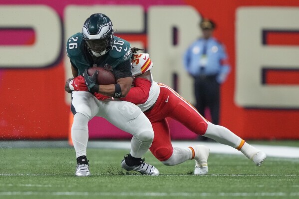 Philadelphia Eagles running back Saquon Barkley (26) catches a pass as Kansas City Chiefs linebacker Nick Bolton (32) defends during the first half of the NFL Super Bowl 59 football game, Sunday, Feb. 9, 2025, in New Orleans. (AP Photo/Doug Benc)