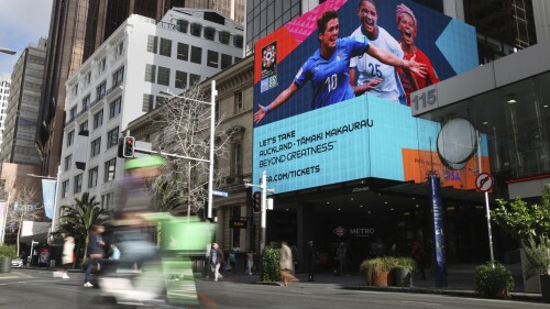 A FIFA Women's World Cup billboard is seen in the central business district ahead of the opening match in Auckland, New Zealand, Wednesday, July 19, 2023. International visitors are greeted at the arrivals hall in Auckland's airport with a display of Women's World Cup branding, including carpeting like a soccer pitch. After that, though, the hype trails off. (AP Photo/Rafaela Pontes)