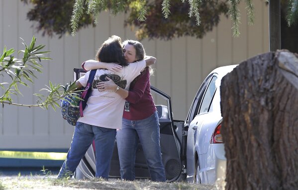 
              Two women embrace outside Rancho Tehama Elementary School, where a gunman opened fire Tuesday, Nov. 14, 2017, in Corning, Calif. Authorities said, a gunman choosing targets at random, opened fire in a rural Northern California town Tuesday, killing four people at several sites and wounding others at the elementary school before police shot him dead. (AP Photo/Rich Pedroncelli)
            