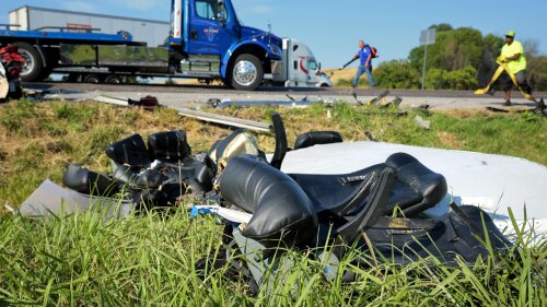 Workers clear debris from westbound Interstate 70 on Wednesday, July 12, 2023, after a Greyhound passenger bus collided with a tractor-trailer near Highland, Ill. (Christian Gooden/St. Louis Post-Dispatch via AP)