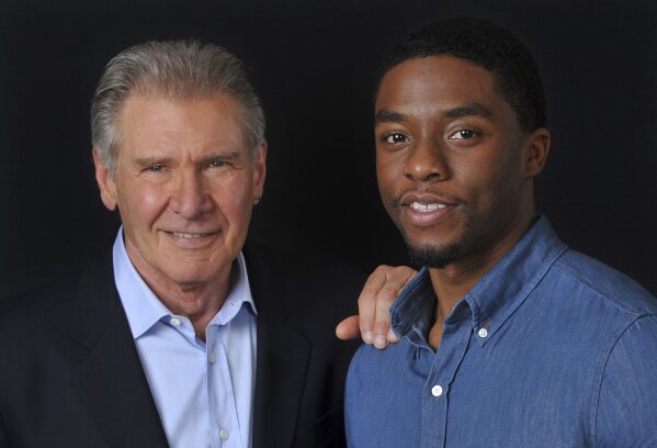 In this Saturday, March 23, 2013 file photo, Harrison Ford, left, and Chadwick Boseman, cast members in the film "42," pose together for a portrait, in Los Angeles.  Boseman, who played Black icons Jackie Robinson and James Brown before finding fame as the regal Black Panther in the Marvel cinematic universe, has died of cancer. His representative says Boseman died Friday, Aug. 28, 2020 in Los Angeles after a four-year battle with colon cancer. He was 43.  (Photo by Chris Pizzello/Invision/AP, File)