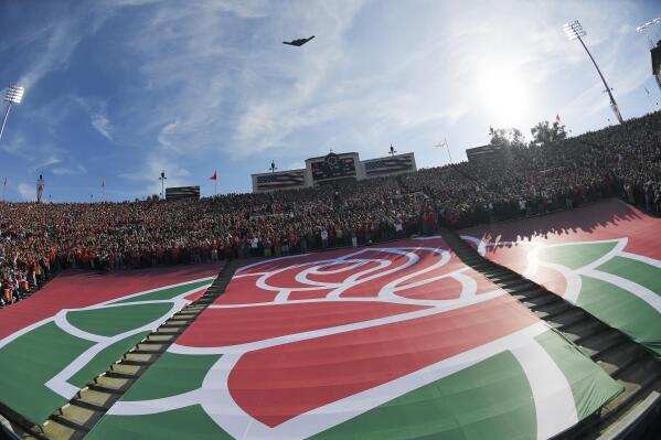 The Rose Bowl logo is seen during a fly over before the Rose Bowl NCAA college football game between Utah and Ohio State Saturday, Jan. 1, 2022, in Pasadena, Calif. Flipping the current college football playoff from four-teams to a 12-teams for the final two years of the current television contract will give those in charge of the postseason a look at how it works before committing to anything long term. But, The Granddaddy of Them All wants the CFP management committee to assure game organizers that their game will continue to be played annually on New Year's Day. (AP Photo/Mark J. Terrill, File)