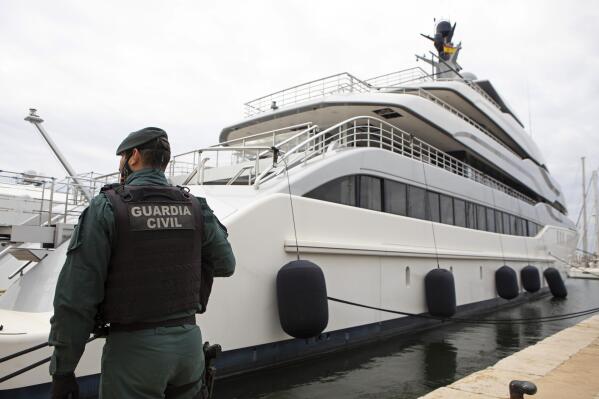 FILE - A Civil Guard stands by the yacht called Tango in Palma de Mallorca, Spain, April 4, 2022. Two businessmen have been charged with trying to conceal a sanctioned Russian oligarch's ownership of the luxury yacht seized in Spain last year by the U.S. government, the Justice Department said Friday, Jan. 20, 2023. (AP Photo/Francisco Ubilla, File)