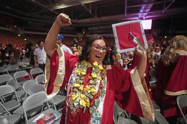 FILE - Amryn Tom reacts after graduating from Cedar City High School on Wednesday, May 25, 2022, in Cedar City, Utah. Tom is wearing an eagle feather given to her by her mother and a cap that a family friend beaded. (AP Photo/Rick Bowmer, File)