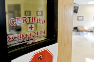 This photo taken Aug. 15, 2016, shows the front of the Bellefonte Area School District certified school nurses office. Schools are confronting soaring absence rates. Some are calling for parents to send their children to class even if they are not feeling 100% well. During the pandemic, schools urged parents and children to stay home at any sign of illness. Now that the COVID-19 emergency has ended, guidance on when to keep children home varies widely. The American Academy of Pediatrics recommends staying home with fever, vomiting or diarrhea, or when students “are not well enough to participate in class.” But many districts go far beyond that, delineating a dizzying array of symptoms they say should rule out attendance. (Abby Drey/Centre Daily Times via AP, file)