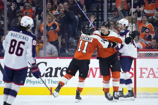 Philadelphia Flyers' Travis Konecny (11) and Sean Couturier (14) celebrate after Konecny's goal during the third period of an NHL hockey game against the Columbus Blue Jackets, Sunday, Nov. 19, 2023, in Philadelphia. (AP Photo/Matt Slocum)