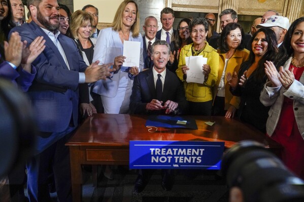 California Gov. Gavin Newsom signs off on two proposals in Los Angeles, Thursday, Oct. 12, 2023, to transform the state's mental health system and address the state's worsening homelessness crisis, putting them both before voters in 2024. (AP Photo/Damian Dovarganes)