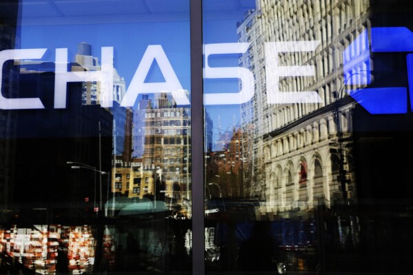 FILE - A Chase bank branch is seen through glass on Jan. 11, 2016, in New York. An unexplained outage at Chase Bank Tuesday, July 25, 2023, has led to interruptions for users of the Zelle payment network, who took to social media to complain. (AP Photo/Mark Lennihan, File)