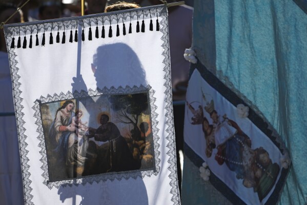 Una mujer lleva la bandera de Nuestra Señora del Rosario durante las Cavalhadas, o Fiesta del Espíritu Santo, en Pirenópolis, estado de Goiás, Brasil, el lunes 9 de junio de 2025. (Foto AP/Eraldo Peres)