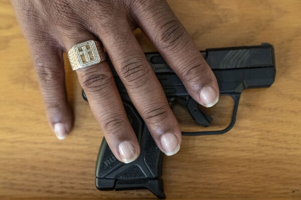 Rev. Jimmie Hardaway Jr. shows the gun he carries on him during services at Trinity Baptist Church Sunday, Aug. 20, 2023, in Niagara Falls, N.Y. One time, when he wasn’t carrying a gun, “I had a guy beat his wife in my office and I couldn’t do anything. He was too big for me. All I could do was say: ‘Stop! Stop!,” he recalls. (AP Photo/David Goldman)
