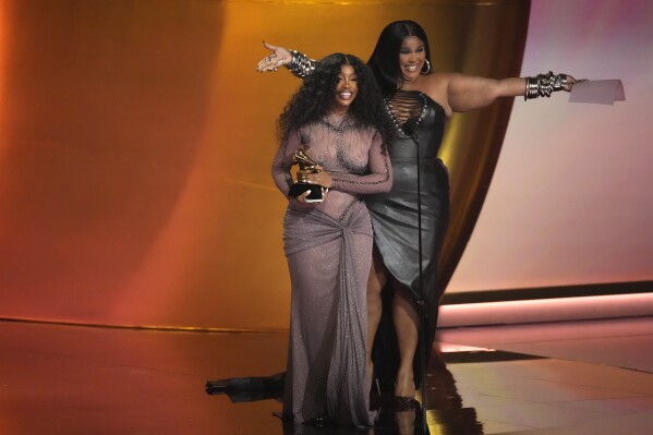 Lizzo, right, presents the award for best R&B song to SZA for 