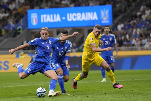 Italy's Davide Frattesi, left, scores against Ukraine during the Euro 2024 group C qualifying soccer match between Italy and Ukraine at San Siro Stadium, in Milan, Italy, Tuesday, Sept.12, 2023. (AP Photo/Antonio Calanni)