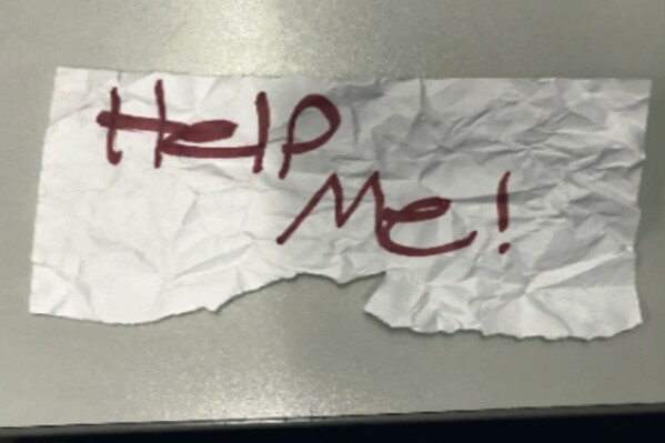 In this undated photo released by the U.S Department of Justice is a "Help Me!" sign used by a 13-year-old girl kidnapped in Texas. The girl was rescued in Southern California on July 9, 2023, when passersby saw her hold up the sign in a parked car, police said. The rescue occurred in Long Beach when officers responded to a trouble call and found the "visibly emotional and distressed girl," police said in a press release Thursday, July 20. (U.S. Department of Justice via AP)