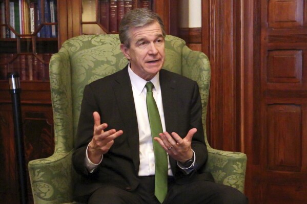 FILE - North Carolina Democratic Gov. Roy Cooper speaks to The Associated Press in a year-end interview at the Executive Mansion, Dec. 14, 2022, in Raleigh, N.C. As Republicans used their legislative heft in 2023 to enact more rightward policies that he opposes, Cooper said Thursday, Dec. 14, 2023, that federal capital investments, Medicaid expansion and more jobs announcements are building historic momentum for the state. (AP Photo/Hannah Schoenbaum, File)