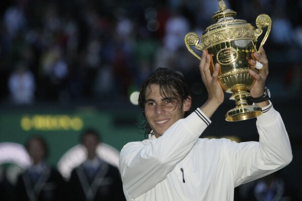 FILE - Spain's Rafael Nadal holds his trophy as he celebrates his defeat of Switzerland's Roger Federer in the men's singles final at Wimbledon, Sunday, July 6, 2008. Nadal is going to skip Wimbledon, as expected, and instead prepare for the Paris Olympics by entering a clay-court tournament in Bastad, Sweden. The 22-time Grand Slam champion said Thursday, June 13, 2024, he wants to just remain on clay, rather than switching over to grass for the All England Club and then needing to go back to clay.(AP Photo/Anja Niedringhaus, File)