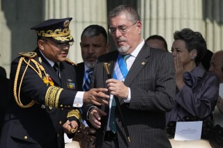 Army Gen. Henry Saenz gives the baton of command to new President Bernardo Arévalo during a ceremony at Constitution square in Guatemala City, Monday, Jan. 15, 2024, the morning after his inauguration. (AP Photo/Moises Castillo)