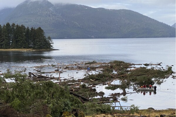 This photo provided by the Alaska Department of Public Safety shows boat operators patrolling the waters near a massive landslide that extends into the sea at mile 11 of the Zimovia Highway, Wednesday, Nov. 22, 2023, in Wrangell, Alaska. Search and rescue operations have been ongoing since the incident was reported Nov. 20, 2023. Three people have died and searchers looked Wednesday, Nov. 22, 2023, for three others who remain missing after a landslide ripped through a remote Alaska fishing community on Monday, Nov. 20, 2023. (Alaska Department of Public Safety via AP)