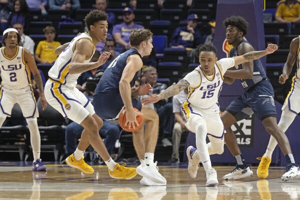LSU forward Jalen Reed (13) and forward Tyrell Ward (15) defend against North Florida guard Nate Lliteras (11) during an NCAA college basketball game Friday, Nov. 24, 2023, in Baton Rouge, La. (Hilary Scheinuk/The Advocate via AP)