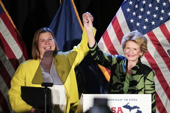 U.S. Senate candidate, Rep. Elissa Slotkin, D-Mich., left, holds hands with Sen. Debbie Stabenow, D-Mich., at a primary election night event in Detroit, Tuesday, Aug. 6, 2024. (AP Photo/Paul Sancya)