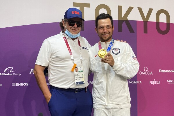 FILE -Xander Schauffele, of the United States, poses with his gold medal in the men's golf event with his dad, Stefan, at the 2020 Summer Olympics on Sunday, Aug. 1, 2021, in Kawagoe, Japan. Schauffele's father caused a stir after the Ryder Cup by airing his complaints about the PGA of America.(AP Photo/Doug Ferguson, File)