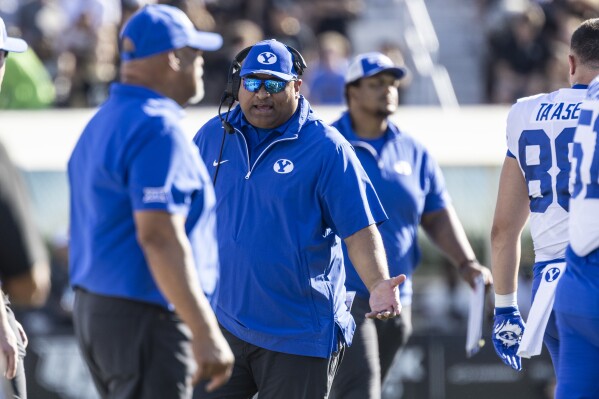 BYU head coach Kalani Sitake, center, react after play against Central Florida during the first half of an NCAA college football game, Saturday, Oct. 26, 2024, in Orlando, Fla. (AP Photo/Kevin Kolczynski)