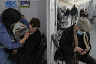 Una persona mayor recibe una tercera inyección de la vacuna AstraZeneca para el COVID-19 durante una campaña para dar inyecciones de refuerzo a personas mayores de 86 años en el estadio Bicentenario en Santiago, Chile, el miércoles 11 de agosto de 2021. (AP Foto/Esteban Félix)