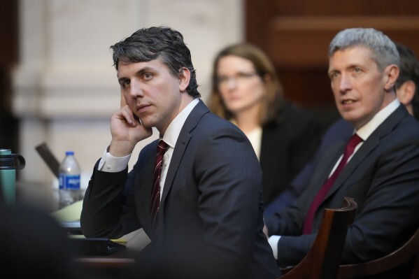 Attorneys Jason Murray, front, and Eric Olson listen as attorney Scott Gessler argues before the Colorado Supreme Court on Wednesday, Dec. 6, 2023, in Denver. (AP Photo/David Zalubowski, Pool)