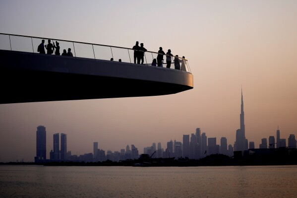FILE - People stand on the observation deck of the Dubai Creek Harbour in Dubai, United Arab Emirates, Sunday, June 18, 2023, to view the city skyline with the world's tallest tower, the Burj Khalifa. Dubai hosts the United Nations COP28 climate talks starting Nov. 30. (AP Photo/Kamran Jebreili, File)