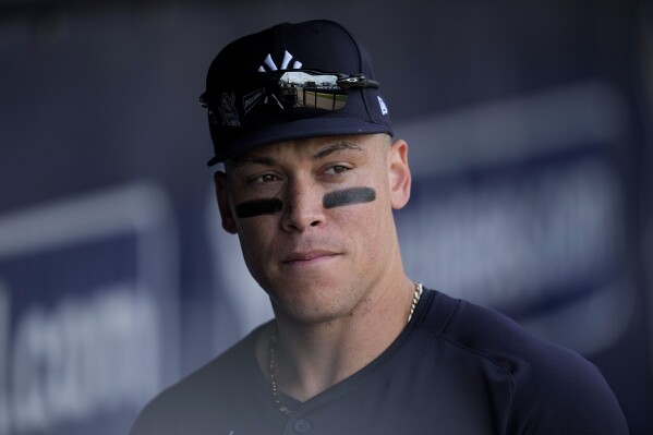 New York Yankees center fielder Aaron Judge stands in the dugout before a spring training baseball game against the Tampa Bay Rays Wednesday, March 6, 2024, in Tampa, Fla. (AP Photo/Charlie Neibergall)
