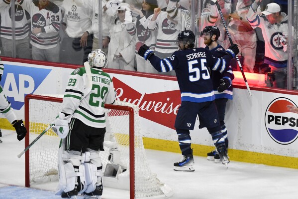 Winnipeg Jets' Mark Scheifele (55) celebrates his goal against Dallas Stars goaltender Jake Oettinger (29) with Kyle Connor (81) during second period NHL playoff hockey action in Winnipeg, Thursday, May 15, 2025. (Fred Greenslade/The Canadian Press via AP)