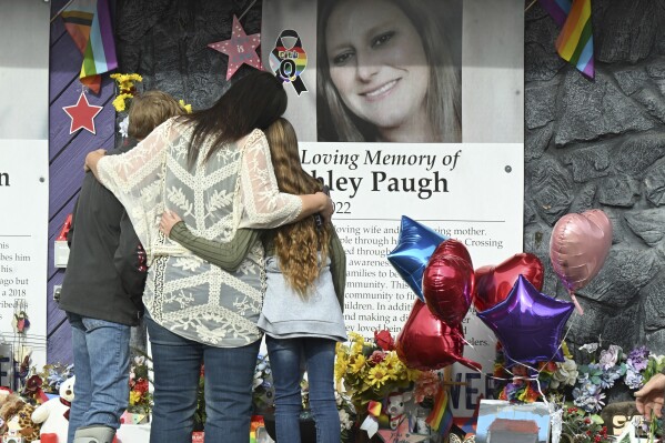 Stephanie Clark hugs her children, Brayson Hochevar and Alexis Clark, before a memorial service marking the one-year anniversary of the Club Q shooting in Colorado Springs, Colo., on Sunday, Nov. 19, 2023. Clark's sister, Ashley Paugh, was among those killed in the LGBTQ+ nightclub shooting. (Jerilee Bennett/The Gazette via AP)