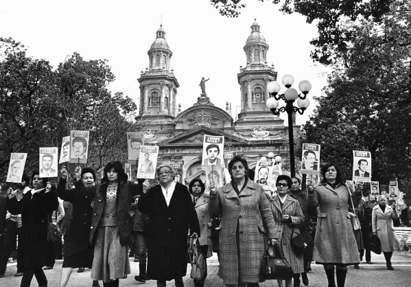 Women protest holding photos of relatives who have been arrested and are missing, in the main plaza of Santiago, Chile, in 1983. (AP Photo/Marco Ugarte)