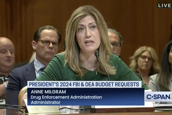 In this image from video provided by C-SPAN, U.S. Drug Enforcement Administration Administrator Anne Milgram speaks during a hearing before the Senate Appropriations Subcommittee on Commerce, Justice, and Science in Washington on May 10, 2023. At center left behind Milgram is Louis Milione. After temporarily leaving the DEA in 2017, like dozens of colleagues in the agency's powerful-but-little-known Office of Diversion Control, Milione immediately went to work as a consultant for some of the same companies he had been tasked with regulating, including Morris & Dickson. He was named deputy administrator in 2021. On another front, a federal watchdog is investigating whether Milgram improperly awarded millions of dollars in no-bid contracts to hire her past associates. (C-SPAN via AP)