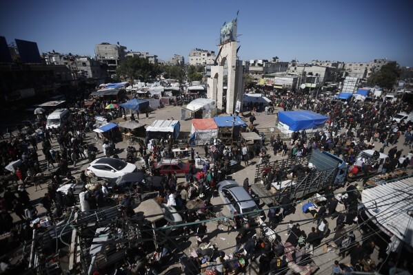 Palestinians crowd a market in Rafah, Gaza Strip, Thursday, Feb. 22, 2024. An estimated 1.5 million Palestinians displaced by the war took refuge in Rafahor, which is likely Israel's next focus in its war against Hamas. (AP Photo/Mohammed Dahman)