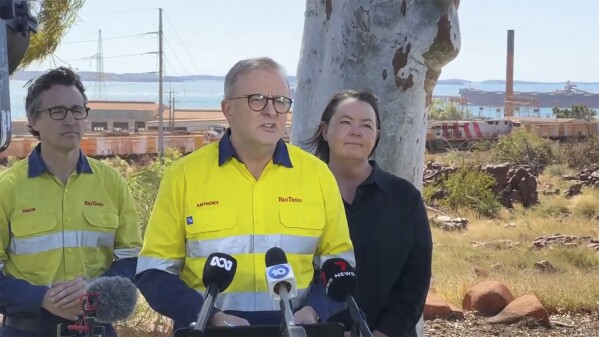 In this image made from video, Australian Prime Minister Anthony Albanese, center, speaks to the media following an aircraft crash in Karratha, Australia, Sunday, Aug. 27, 2023. Three United States military personnel were taken to a hospital, one with critical injuries, after a U.S. aircraft crashed on a north Australian island Sunday during a multination military exercise, officials said. (AuBC via AP)