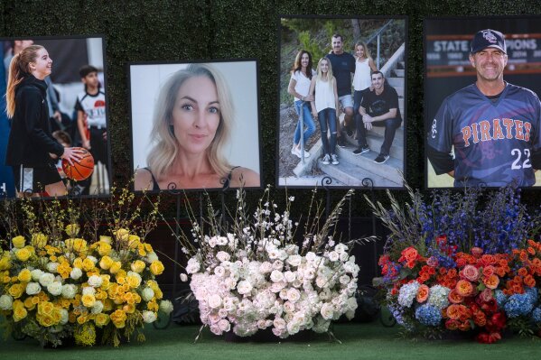 FILE - In this Feb. 10, 2020 file photo, flowers and photos honor members of the Altobelli family outside Angel Stadium in Anaheim, Calif. Coach John Altobelli, 56, far right, his wife, Keri, 43, second from left, and his daughter Alyssa, 13, left, died in a helicopter crash on Jan. 26 in Calabasas. Family members of four of the people killed in a helicopter crash with Bryant and his daughter are suing the companies that owned and operated the aircraft. The wrongful death lawsuits were filed electronically Sunday, April 19, 2020 in Los Angeles Superior Court on behalf of three members of one family and a woman who helped coach Bryant's daughter in basketball. One suit was filed by two children of Orange Coast College baseball coach John Altobelli,his wife and daughter, who played basketball with Gianna. Another suit was filed by the husband and three children of Christina Mauser, who helped Bryant coach the girls' basketball team. (AP Photo/Damian Dovarganes, File)