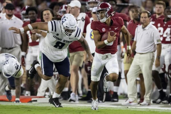 Alabama quarterback Bryce Young, front right, runs with the ball against Utah State defensive lineman Hale Motu'apuaka (8) during the first half of an NCAA college football game Saturday, Sept. 3, 2022, in Tuscaloosa, Ala. (AP Photo/Vasha Hunt)