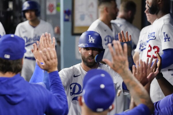 Los Angeles Dodgers' Chris Taylor celebrates in the dugout after scoring against the Arizona Diamondbacks during the second inning of a baseball game Tuesday, Aug. 29, 2023, in Los Angeles. (AP Photo/Ryan Sun)