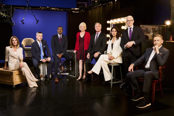 This image released by CBS News shows, from left, Sharyn Alfonsi, L. Jon Wertheim, Bill Whitaker, Lesley Stahl, Scott Pelley, Cecilia Vega, Anderson Cooper and Executive Producer Bill Owens, from the CBS news series "60 Minutes." (Jai Lennard/CBS News via AP)