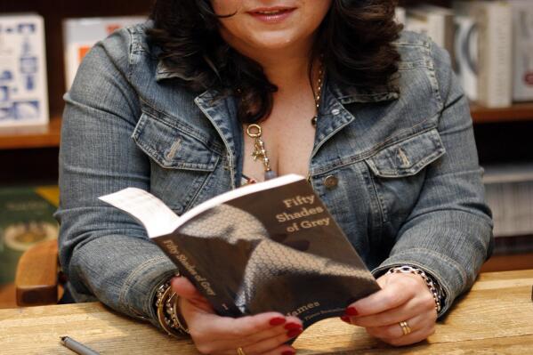 Author E L James holds a copy of her new erotic fiction book "Fifty Shades of Grey" at a book signing in Coral Gables, Fla., Sunday, April 29, 2012. (AP Photo/Jeffrey M. Boan)