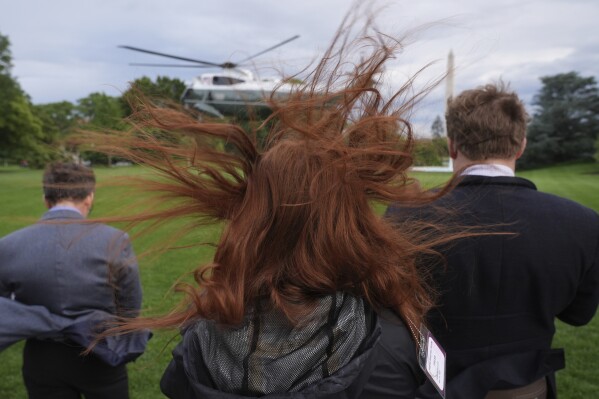 People watch as Marine One, with President Donald Trump aboard, departs the White House en route to Trump National Golf Club Washington DC for a crypto dinner, Thursday, May 22, 2025, in Washington. (AP Photo/Jacquelyn Martin)
