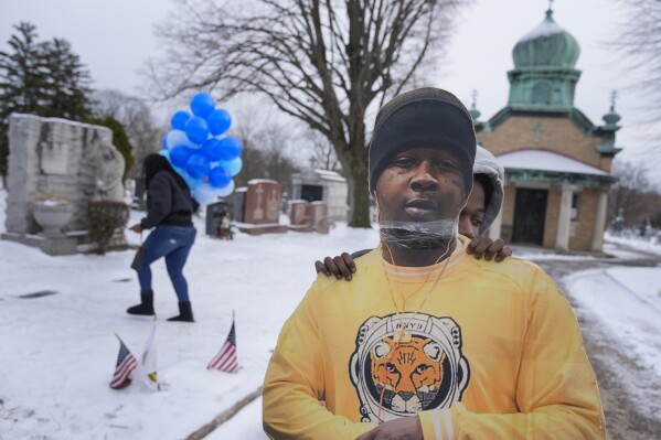 Timere Jones, right, carries a life-sized picture of his brother, Jameek Lowery, as he and others visit Lowery’s grave in Garfield, N.J., Thursday, Jan. 18, 2024. Lowery was among more than 300 Black people who died after encounters with police in which officers used force that isn’t supposed to be fatal -- including restraints, punches and stun guns -- The Associated Press found in documenting a decade’s worth of such cases. (AP Photo/Seth Wenig)
