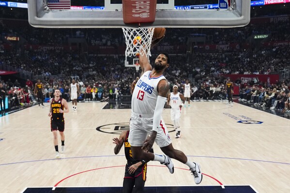 FILE - Los Angeles Clippers forward Paul George (13) dunks during the first half of an NBA basketball game against the Atlanta Hawks in Los Angeles, Sunday, March 17, 2024. George will sign a four-year, $212 million contract with the Philadelphia 76ers, a person with knowledge of the move told The Associated Press early Monday, July 1, 2024. (AP Photo/Ashley Landis, FIle)