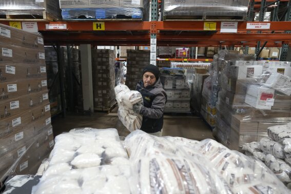 Driver Carlos Quezada loads rice on a pallet for distribution at Feeding Westchester in Elmsford, N.Y., Wednesday, Nov. 15, 2023. A growing number of states are working to keep food out of landfills over concerns that it is taking up too much space and posing environmental problems. Some states including New York are requiring supermarkets and other businesses to redirect food to food pantries. (AP Photo/Seth Wenig)