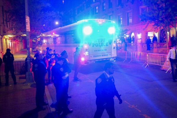 Un autobús policial que transporta a manifestantes arrestados en la Universidad de Columbia sale de la entrada del campus en la calle 114, el martes 30 de abril de 2024, en Nueva York.  Después de ingresar al campus, un grupo de policías se acercó a Hamilton Hall, el edificio administrativo que los estudiantes manifestantes habían comenzado a ocupar ese mismo día.  (Foto AP/Julius Modell)